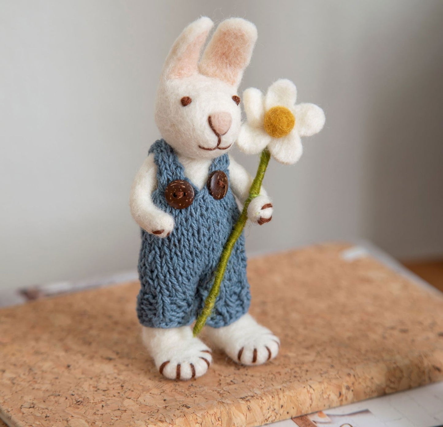 Weißer Hase mit blauer Hose und Margerite