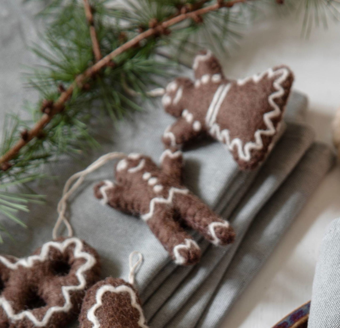Handgefilzte Lebkuchen-Weihnachtsornamente aus Wollfilz – Fair-Trade-Handarbeit aus Nepal im skandinavischen Design von Gry & Sif.