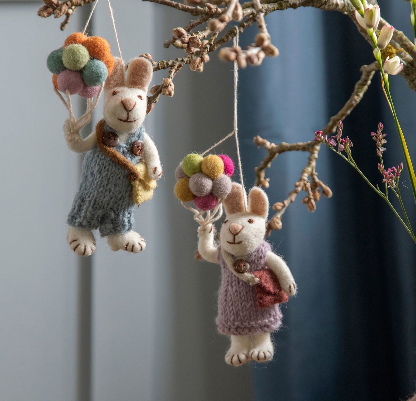 Weißes Hasenmädchen mit Lavendelkleid und Ballons