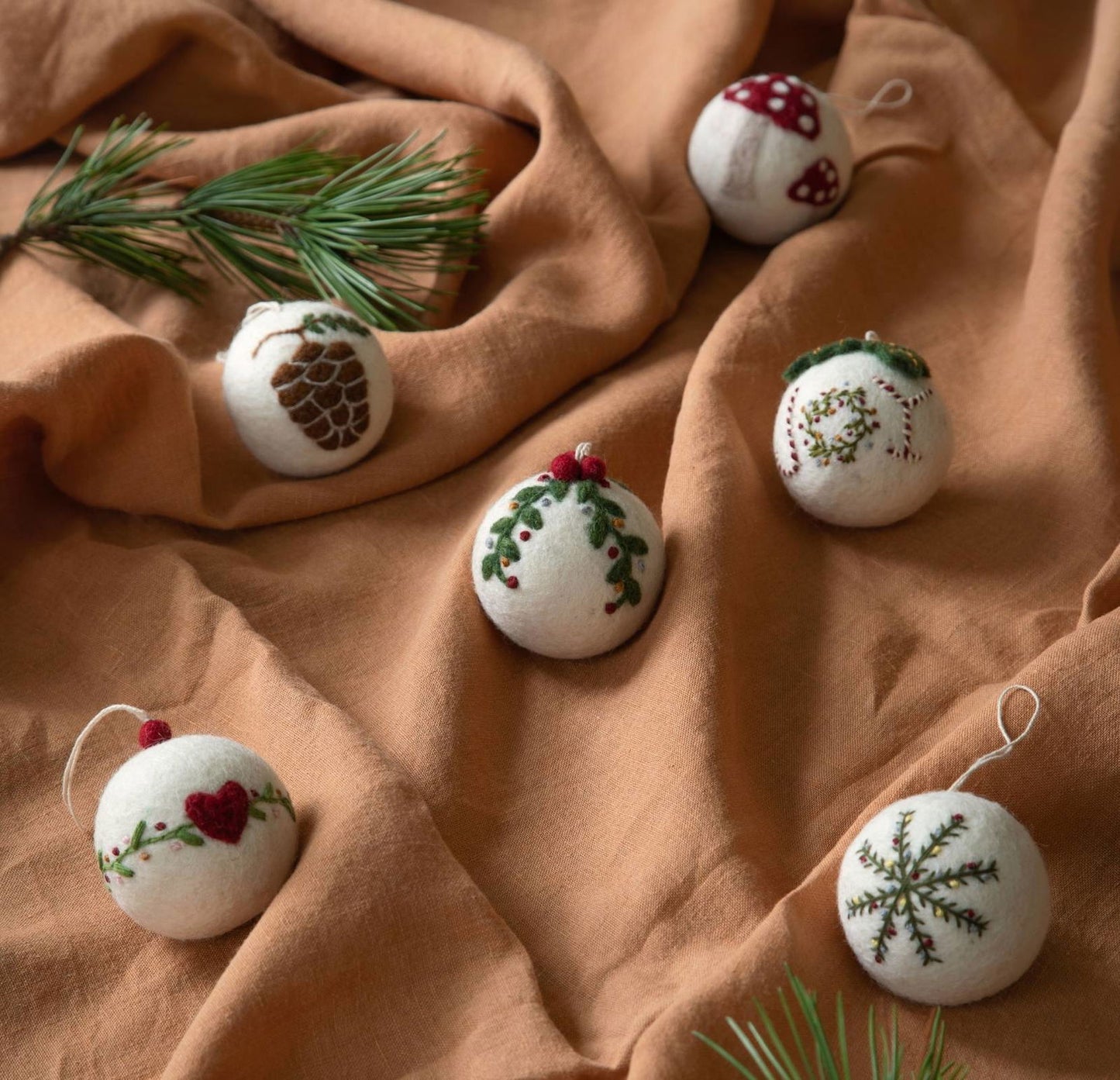 Drei weiße handgefertigte Filzanhänger von Gry & Sif – Herz, Pilz und Girlande aus 100 % Wolle, Fair Trade produziert